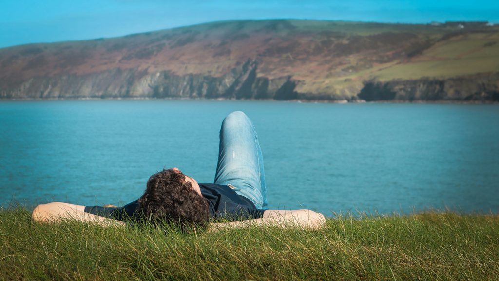 Solo entrepreneur relaxing away from the laptop, illustrating work-life balance.